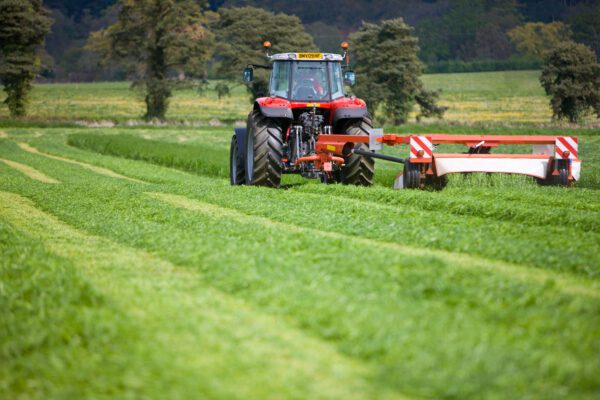 tractor maait gras om er kuilvoer van te maken